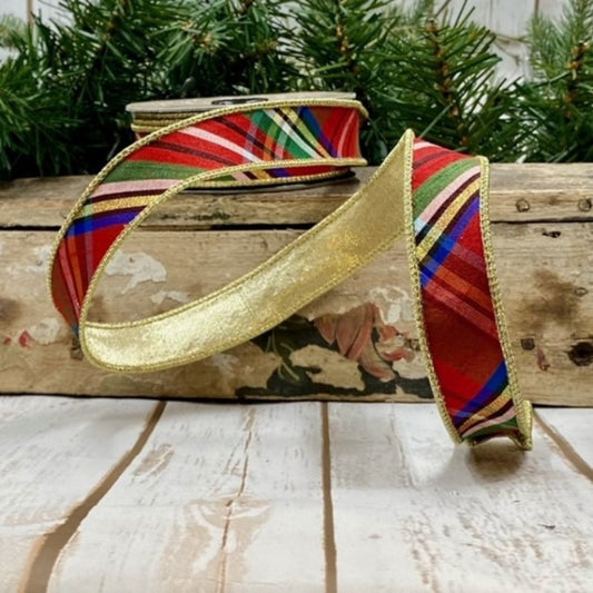A faux dupion ribbon with a diagonal nutcracker plaid pattern in gold, blue, red, and green, placed on a white wooden surface.