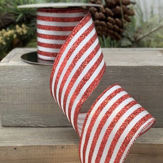 Red and white striped ribbon with glitter on a wooden surface