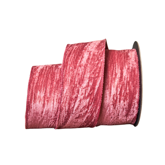 Spool of pink velvet ribbon on a white background