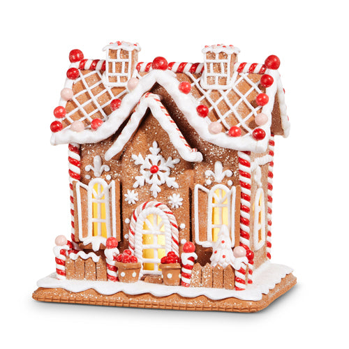 Clay dough decorative gingerbread house with candy details on a white background