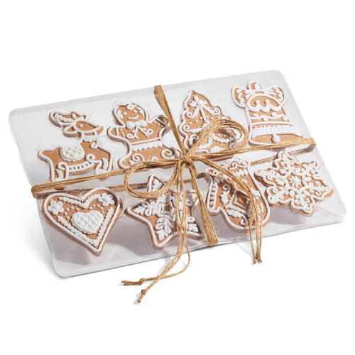 Decorative packaging with gingerbread-themed cookies ornaments tied with twine on a white background