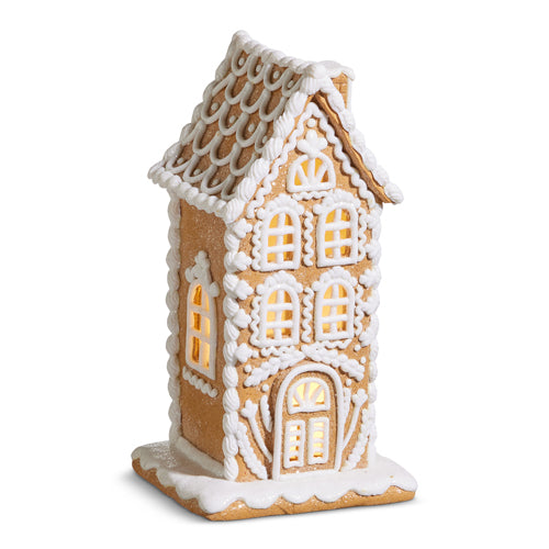 Decorative gingerbread house with white icing on a white background