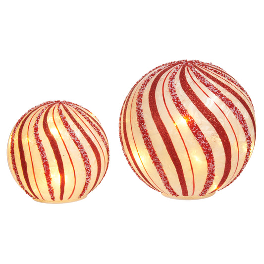 Two red and white striped decorative balls on a white background