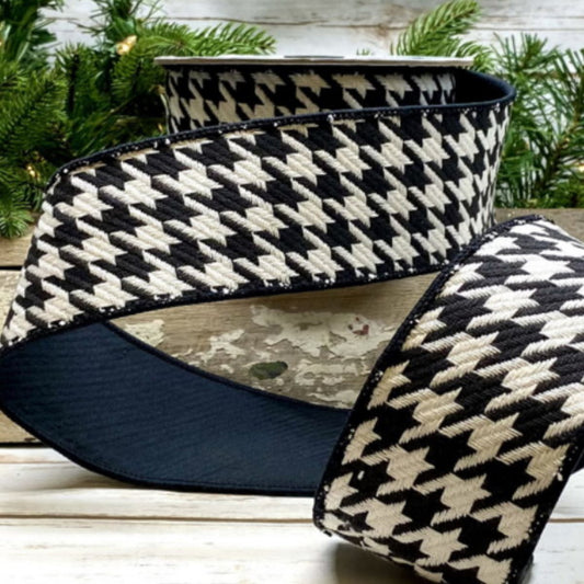 A spool of cotton houndstooth ribbon with black back and black/white pattern, displayed on a wooden surface.