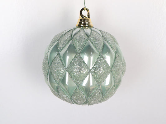 Decorative Christmas ball with diamond pattern and glitter on a white background