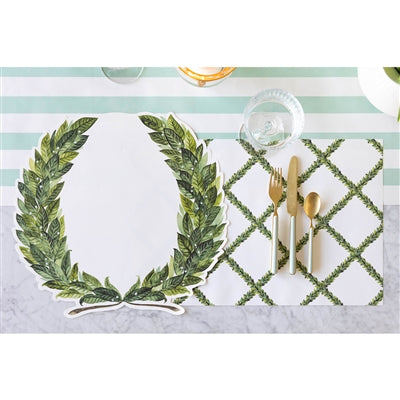 Placemats with leaf design and gold cutlery on a striped background
