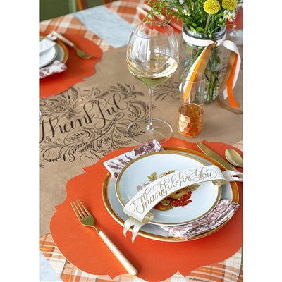 Thanksgiving table setting with place cards and decorative elements.