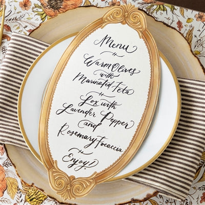 Decorative menu card with gold frame on a table setting with plates and napkins.