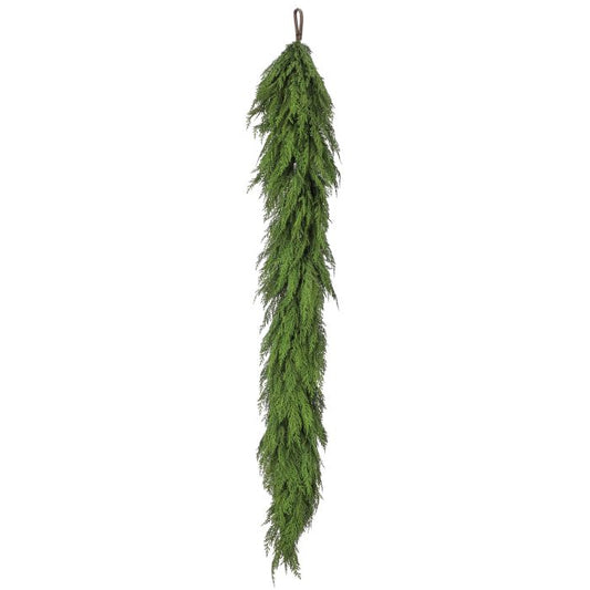 Green artificial garland hanging on a white background