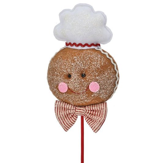 Gingerbread man cookie on a stick with a chef's hat and bow tie against a white background
