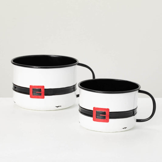 Two white pots with black handles and red belts on a white surface.
