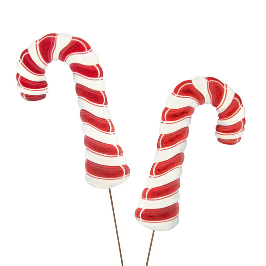 Two red and white striped candy canes stake on a white background
