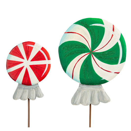 Two large lollipops stake, one red and white, one green and white, on a white background.