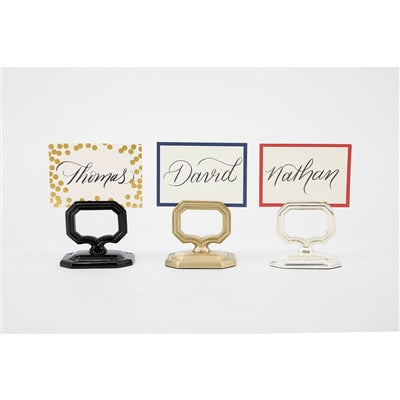 Four name card holders with different designs on a white background