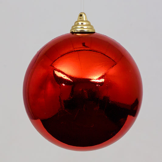 Red Christmas ball ornament with gold cap on a gray background