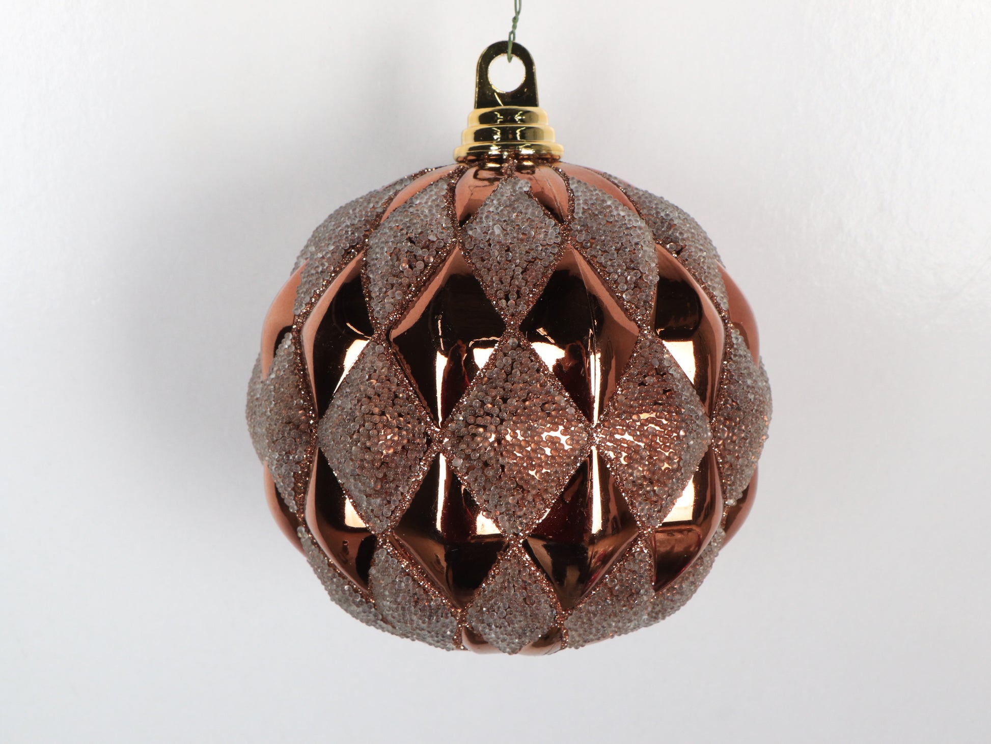 Decorative Christmas ball ornament with a geometric pattern on a light gray background