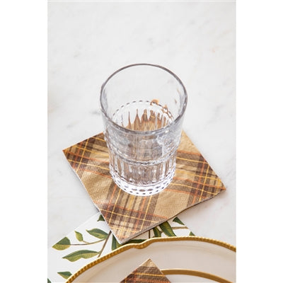 Clear glass of water on a plaid cocktail napkin with a white background