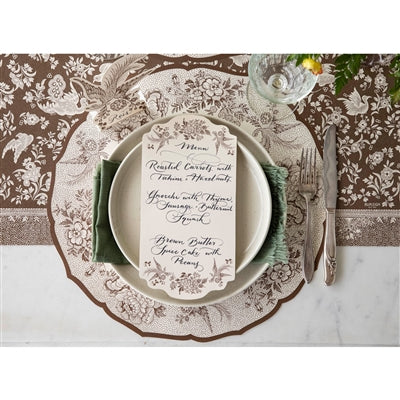 Elegant table setting with a decorative menu card on a patterned placemat.